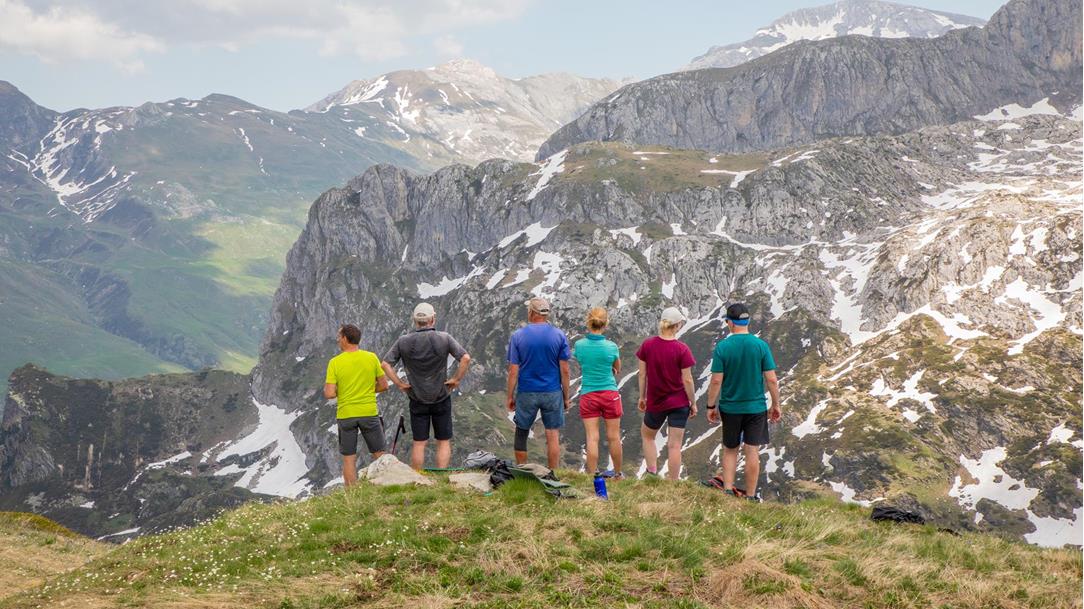 Eine Wandergruppe steht auf einem Aussichtspunkt in den Seealpen und blickt auf die umliegenden Berggipfel und Täler